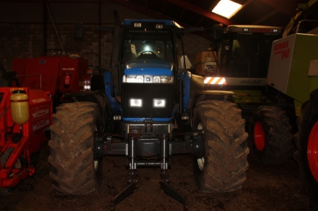 Tractor, New Holland 8970A, 4WD, hours: 9362. Year 2003. Hydraulic front lift, Zuidberg Frontline Systems, SN: 23037048. Lift capacity: 35 kN. Good tires. Discord between the gearbox and engine. Runs OK