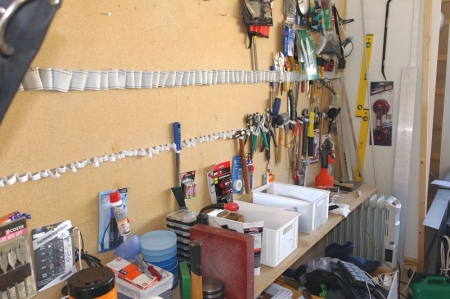 Håndværktøj på væg og hylde. Kasse med skruetrækkere + klinger + pensler + hammer + vaterpas og linealer i hjørne.