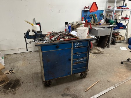 Workshop table on wheels containing various tools, vices, etc.