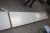 Bordplade, hvid melamin. Bredde ca. 60 cm. Længde ca. 400 cm + spånplade