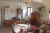 Left hand side of livingroom: Dining table, chairs, refrigerator, plants, m / m