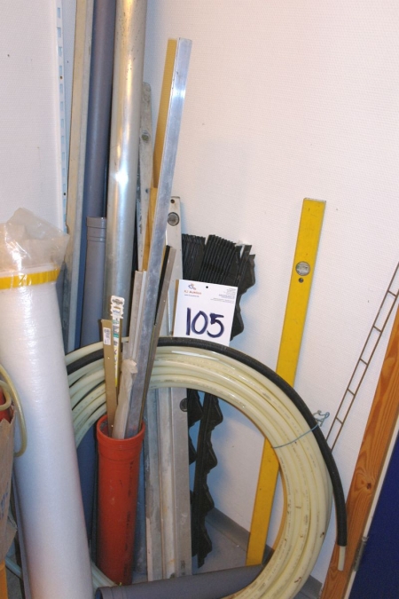 Various in corner: pipes + bubble level + hose, etc.