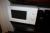 Vægreol med 3 hylder med indhold: kopper + drikkeglas + mikroovn/grill, OBH Nordica + koldtvandsautomat, Waterpoint + mikroovn, Sharp 210 A + 6 termokander med videre
