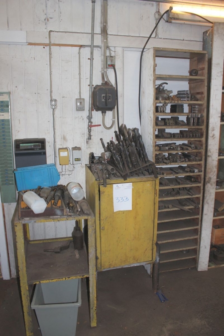 Table, cabinet and rack with content containing various drills, etc.
