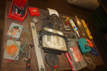 Table containing various hand tools + Work Light + pliers + drill, etc.
