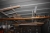 Materialecontainer, 20 fod, lys. Indhold, bl.a. arbejdsbord med skruestik, forbrugsmaterialer, søm og skruer, aflægningsbukke med videre