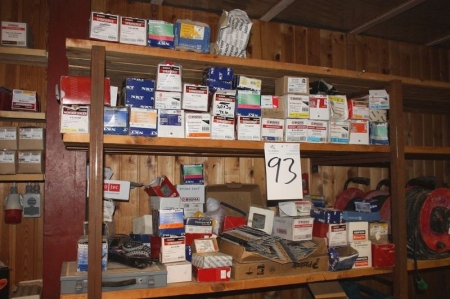 Content on 3 shelves in a wooden rack, including: screws, clout nails, outdoor screws nail dovels, nails for nail gun