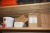 Parti tomme kasser på toppen af træreol og indhold på 1 hylde i 3 fag træreol