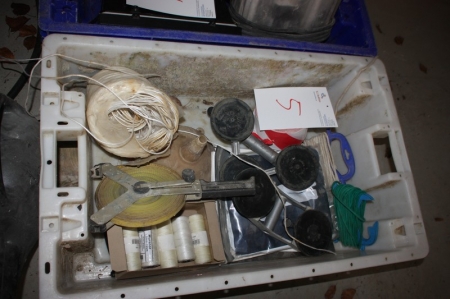 Box with various items, including plumb line, measuring tape, suction cups with handles