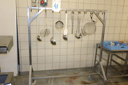 Stainless steel rack on wheels with various kitchen utensils