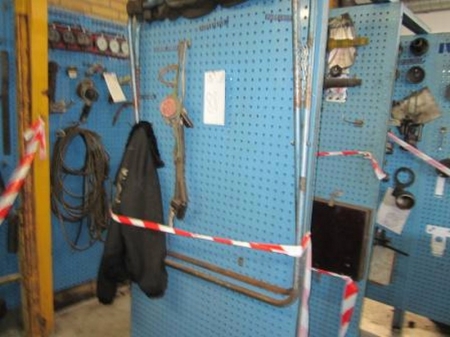 Panel with window frame, mask, crowbars, sledge hammers and other tools