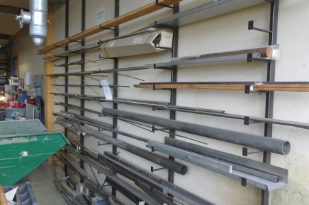 Material rack on wall containing various turning steel + iron + square brass rods, etc.