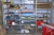 Steel Shelving with content wheels + chain + parts + exhaust pipe supports, etc.