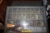 Reol med rullefront med indhold af bl.a. ubrugte murbor, metalbor, kasse med stifter for Ruko 5  med videre