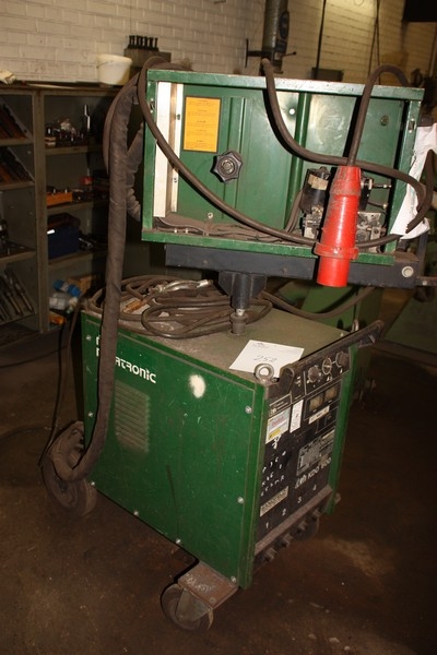 Welding rectifier, Migatronic KDO 600 + wire feed unit (missing covers, labeled "Defective"). Mounted in a frame on wheels