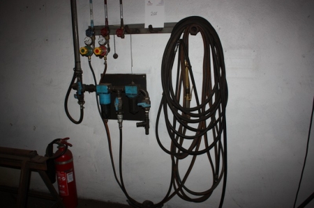 Oxygen and acetylene hoses on the wall with torch and pressure regulator, Morris. + Air hose