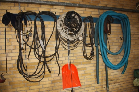 Wall rack with content including power cables, flexible hose, shovel, etc.