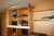 Diverse kontormøbler og dele i reoler på loft som afbildet