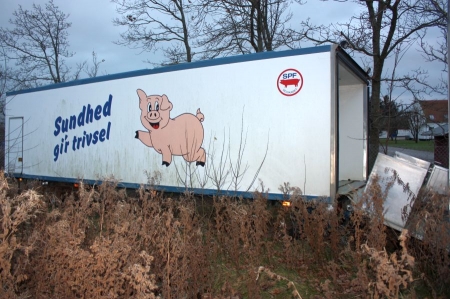 Lastvognslad med lukket kasse med læssebagsmæk. Indrettet til grisetransport