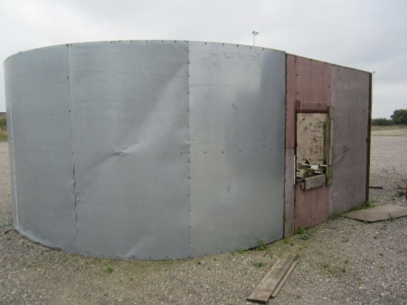 Metal profile shed and sheets of wood / tin roof, about 2,4x5,5 xH 5.5 meters, can be moved with a forklift, containing pallets etc.