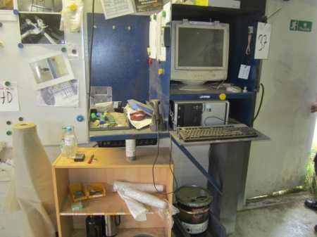 Arbejdsstation med computer, skærm, tastatur og håndscanner og lille reol