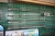 Wall shelf with 8 rails into 3 sections. Shelves with glass front edge. 8 shelves á 1,6 m + 4 shelves of 1 meter. Sold without content