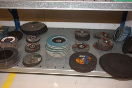 Various sandpaper, sanding blocks, cutting discs, flap discs on two shelves and on the floor