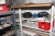 Steel shelving and wooden bookcase containing various electrical supplies