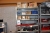 Shelving containing various spare parts for Kverneland piston liners + Spear + rubber strips to door + cutter knives + boxes on the bottom shelf, everything must be accompanied