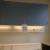 Vægmiljø med vask, bord med højtrykslaminat skuffeskab,overskabe, lysarmatur, Elpanel, mål L: 300 H: 205 D: 85 cm.