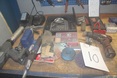 Content on the workbench, various aku tool aku caulking gun with battery and charger, etc.