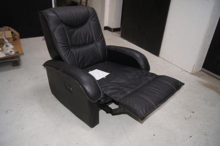 Armchair in black leather look, has built stool which can be turned off.
