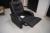 Sessel in schwarzem Leder-Look, hat eine eingebaute Hocker, die ausgeschaltet werden kann.