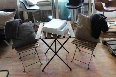 Small table with two folding chairs, pillows and blankets and frames