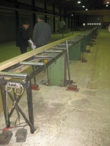 Profile Planer, Kupfermühle, 300 mm, Year of Manufacture: 1983, SN: 10810, with sawing engine above the infeed line, top and bottom planer, programmable height adjustment, 32 meter roller conveyor with elevation on both sides of the conveyor + 32 meter driven runoff roller conveyor; Gluing station after the profile planer: 1 for white glue and one for brown glue