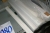 Indhold i 3 fag stålreol + på gulv: slibehoveder for ligeslibere, plexiglas, keramik, låseringe, (3) kasser presenninger (armeret, 6x10 m)