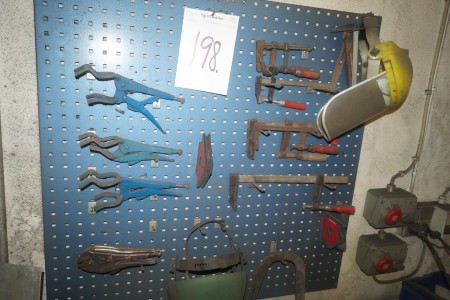 Workshop board with welding pliers and clamp.