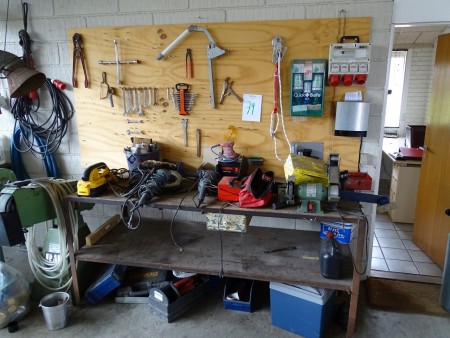 Arbejdsbord med indhold af værktøj + tavle med værktøj.