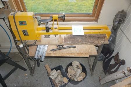 Tru wooden lathe with various tools on the wall.