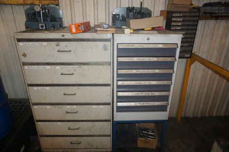 Tool drawer section containing platter, drill, with + assortment rack on wall with content.
