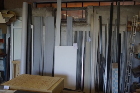 All along the wall of various moldings steel moldings, ethereal debris, window frame and roller with roof.