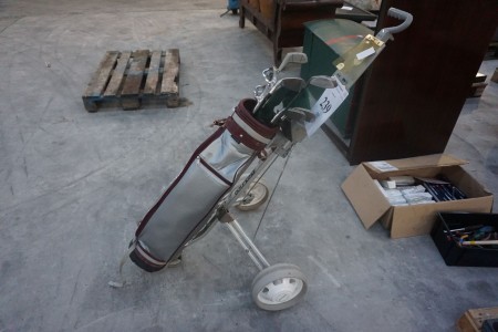 Golf cart with golf clubs.