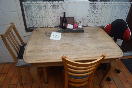 Tisch mit Stühlen und Bücherregal.