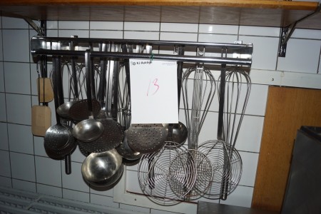 Various soup spoons etc. on a rack.