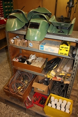 Bookcase with various welding parts. welding electrodes, helmet, pressure gauge, box of MIG spray, welding glass, etc.