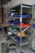 Steel shelf containing various drills, cup drills, welding glasses, etc.