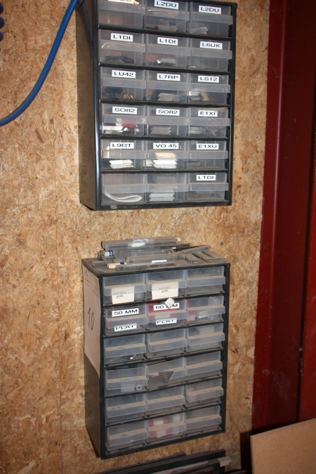 2 assortment boxes on the wall containing tool bit tips etc.