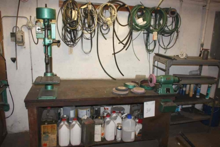 Work table with content: bench drill + bench grinder with various extra grinding wheel + Tool rack with content + peg rack with toothed belts, hoses, etc.