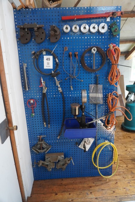 Content on workshop board of various parts for pipe bends, jump leads, etc.