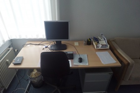 Schreibtisch mit Bürostuhl, Bildschirm und Schrank